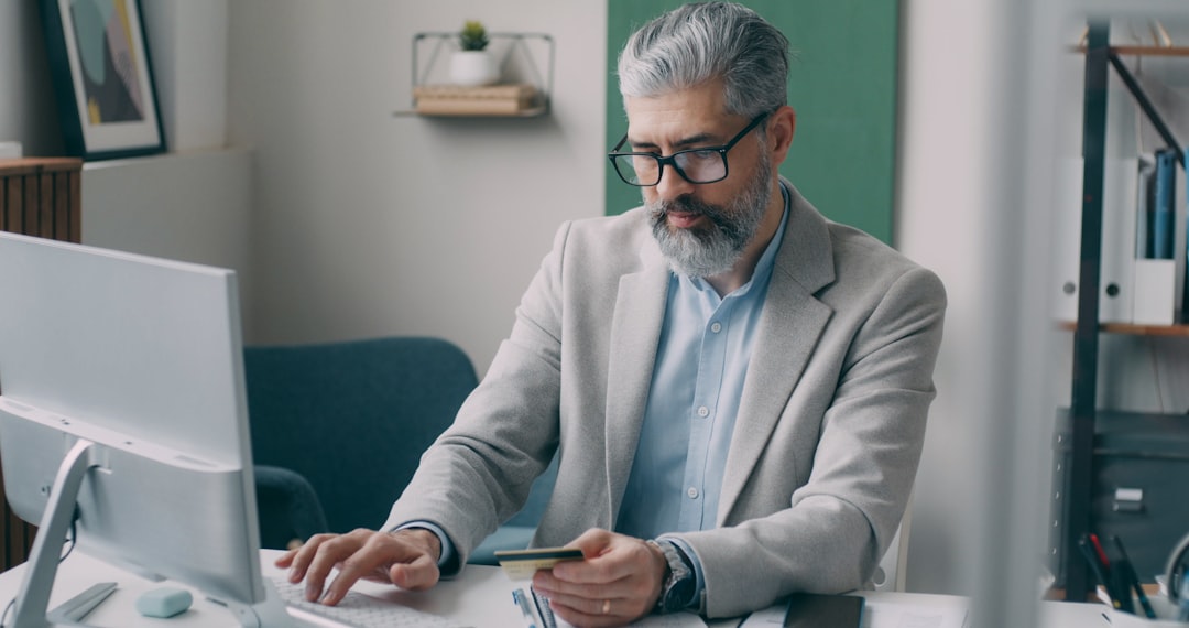a-man-sitting-at-a-desk-using-a-laptop-computer-wcyu-dhnn7u