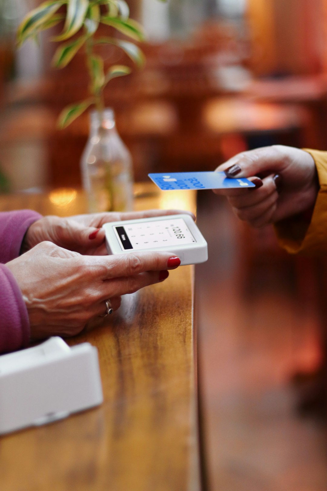 two-people-exchanging-a-credit-card-at-a-table-kaubwnuzjvg